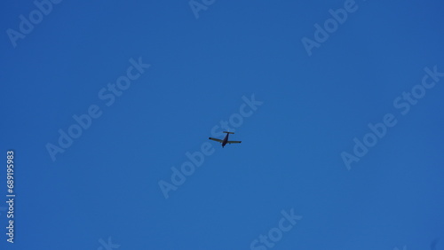 An airplane flying through the clear blue sky in the sunny day