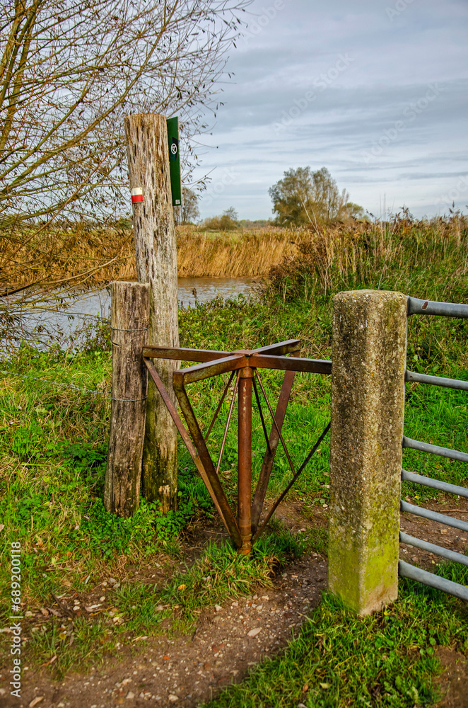 Woudrichem, The Netherlands, November 8, 2023: steel wood and concrete as part of a fence with a rotating element as part of a hiking trail