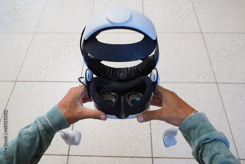 POV Virtual Reality headset and controllers in male hands.