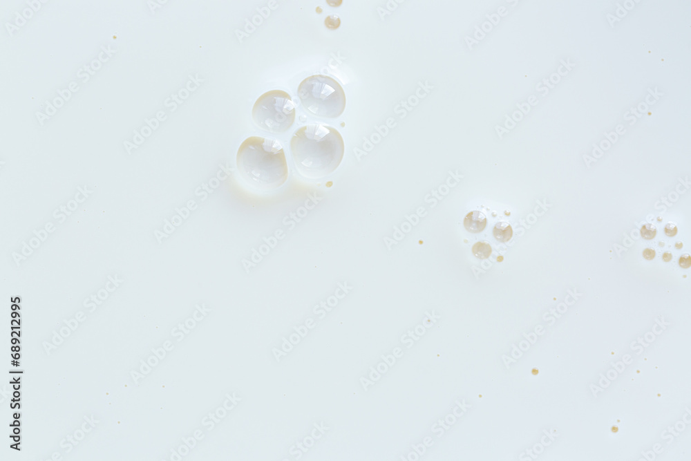 Macro milk close-up texture,Over head close up full frame background detail view of frothy white milk creating bubbles, indoors. Macro still life view of liquid milk drink Macro milk close-up texture,Over head close up full frame background detail view of frothy white milk creating bubbles, indoors. Macro still life view of liquid milk drink