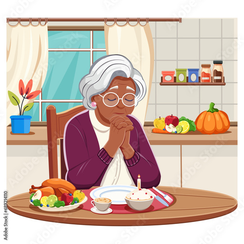 An elderly African-American woman in the kitchen at the table alone praying before the Thanksgiving meal. Prayer, religious culture.