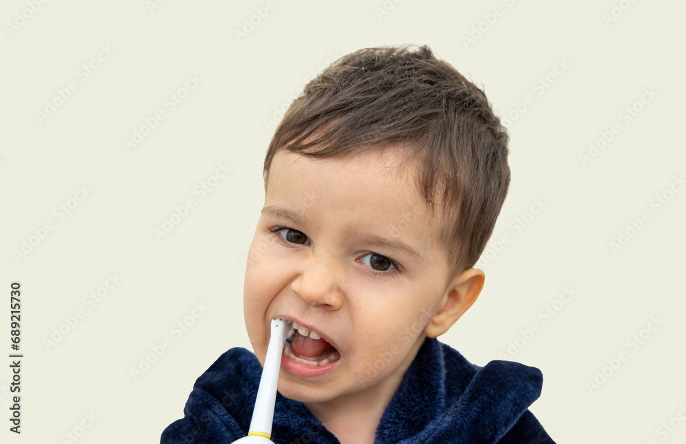 cute little baby boy in bathrobe isolated cleaning teeth with electric brush. mother hand help kid brushing milk teeth.adorable child having daily hygiene mock up banner for advertising, free space cute little baby boy in bathrobe isolated cleaning teeth with electric brush. mother hand help kid brushing milk teeth.adorable child having daily hygiene mock up banner for advertising, free space