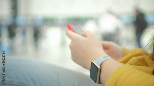 Close up business woman hands using smartphone texting inside airport terminal while waiting for the flight, mobile phone checking emails, business trip, cellphone and travel luggage 4K photo