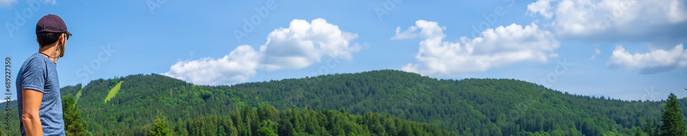 A man in the mountains looks. Selective focus. Selective focus.