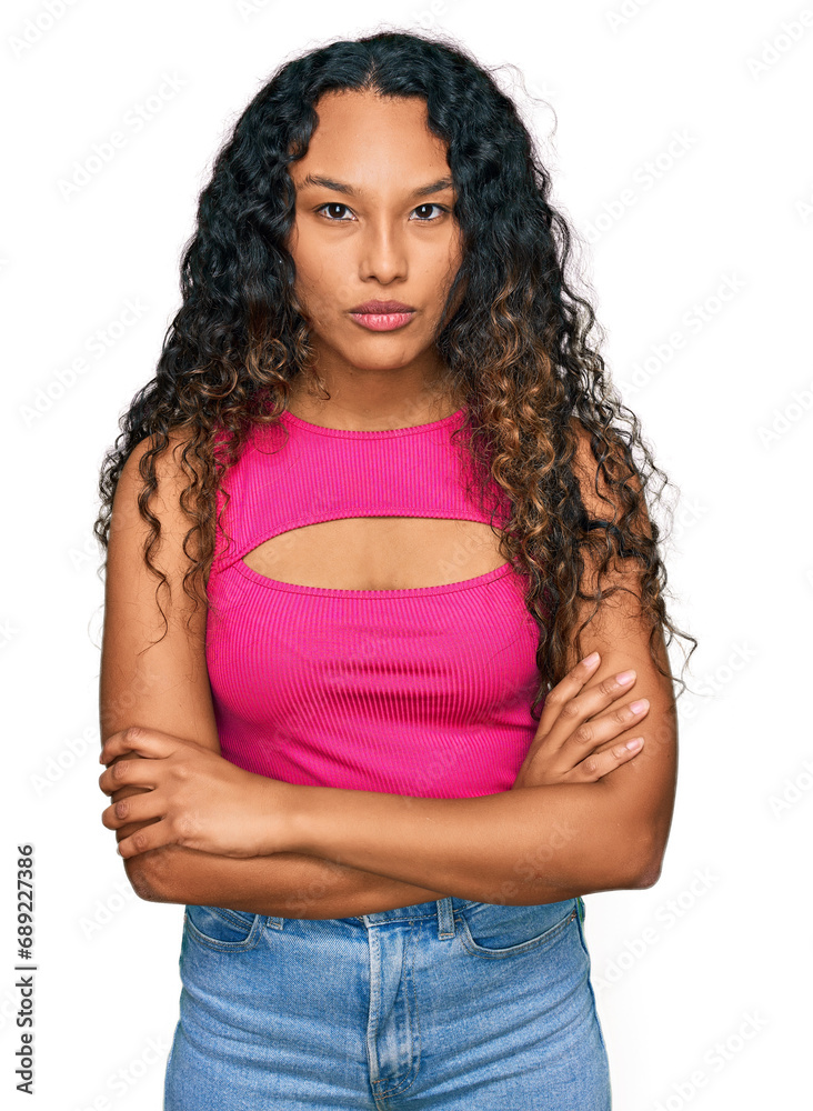 Young hispanic woman with curly hair wearing pink top skeptic and nervous, disapproving expression on face with crossed arms. negative person. Young hispanic woman with curly hair wearing pink top skeptic and nervous, disapproving expression on face with crossed arms. negative person.