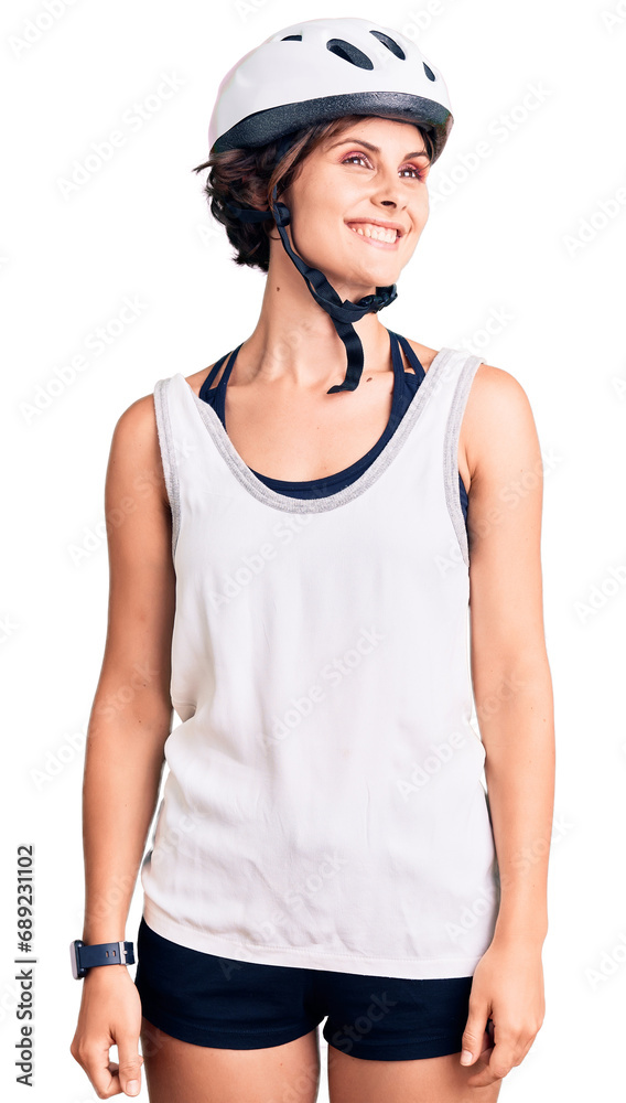 Beautiful young woman with short hair wearing bike helmet looking away to side with smile on face, natural expression. laughing confident. Beautiful young woman with short hair wearing bike helmet looking away to side with smile on face, natural expression. laughing confident.