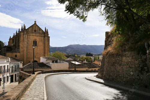 Streets of Ronda city with its historical houses and the Church of The Holy Spirit