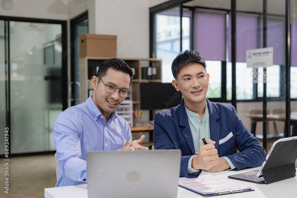 Two Asian businessmen discuss pitching startup ideas, brainstorming ideas, analyzing and planning for business success. Two Asian businessmen discuss pitching startup ideas, brainstorming ideas, analyzing and planning for business success.