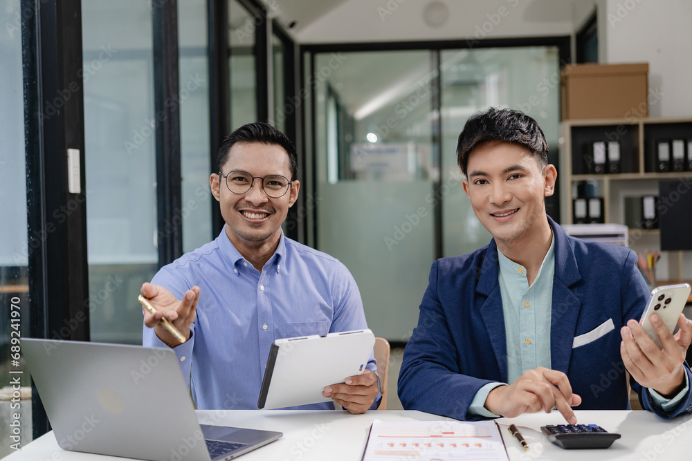 Two Asian businessmen discuss pitching startup ideas, brainstorming ideas, analyzing and planning for business success. Two Asian businessmen discuss pitching startup ideas, brainstorming ideas, analyzing and planning for business success.