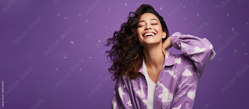 Laughing woman in pajamas on a starry purple background. Free space for product placement or advertising text.