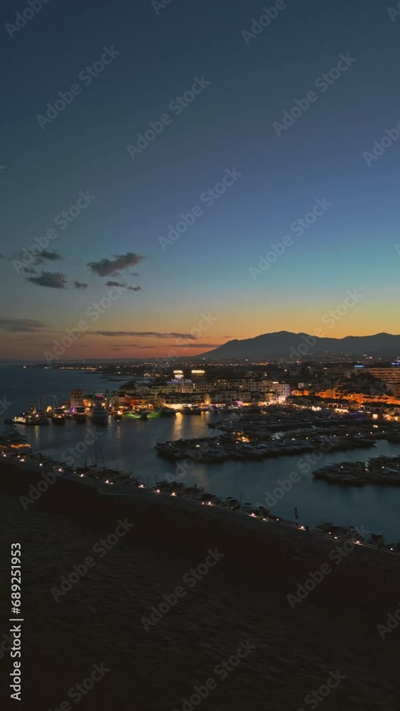 Aerial vertical screen view of Puerto Banus marina luxury port Marbella Costa del Sol coastline Spain at sunset. Travel vacation holidays in Spain Aerial vertical screen view of Puerto Banus marina luxury port Marbella Costa del Sol coastline Spain at sunset. Travel vacation holidays in Spain