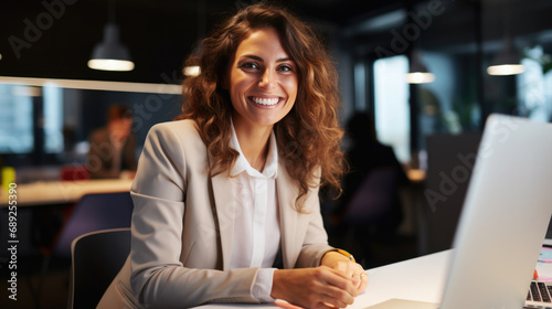 Happy smiling woman working on a laptop in the office