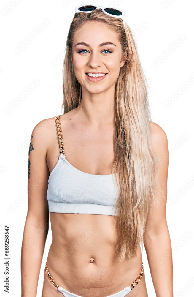 Obraz premium Beautiful young blonde woman wearing bikini with a happy and cool smile on face. lucky person.