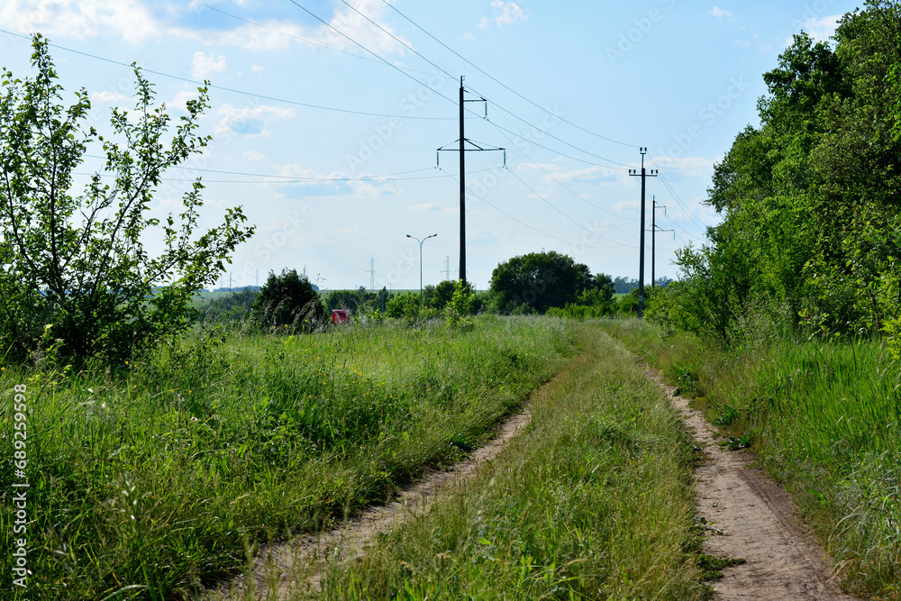 trailway in the field with line of electric pylons