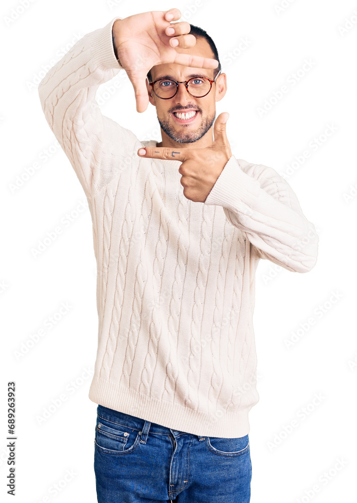 Fototapeta premium Young handsome man wearing casual clothes and glasses smiling making frame with hands and fingers with happy face. creativity and photography concept.
