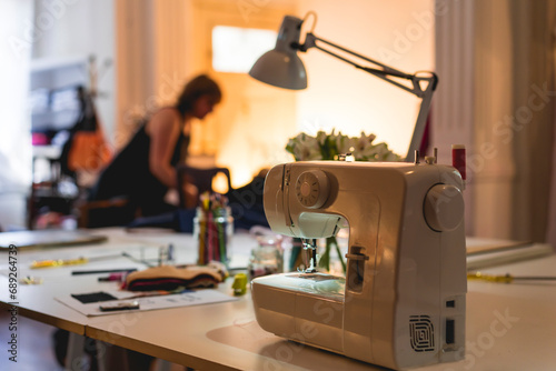 Modern sewing machine on table at fashion studio and showroom photo