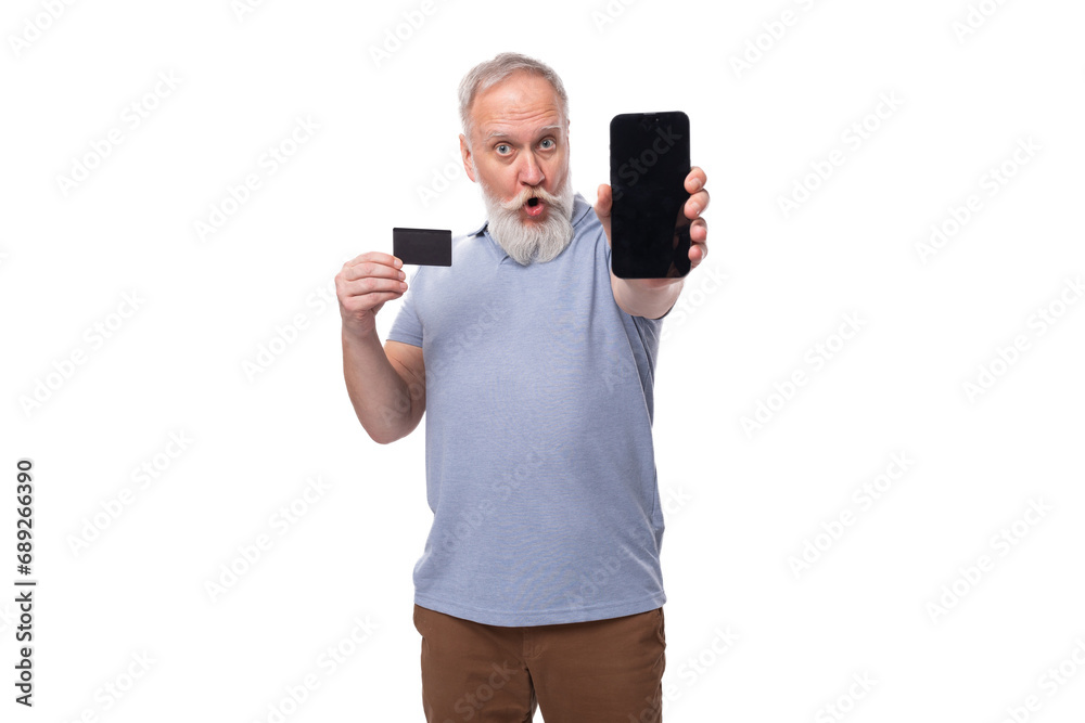 stylish pensioner man with beard and mustache in shirt and trousers holds plastic card mockup and smartphone stylish pensioner man with beard and mustache in shirt and trousers holds plastic card mockup and smartphone