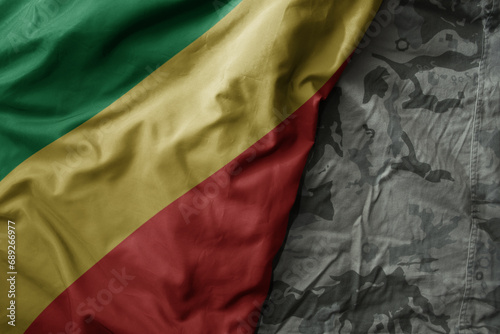 waving flag of republic of the congo on the old khaki texture background. military concept.