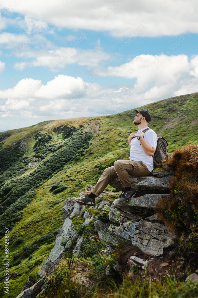 Man in the mountains sitting on a rock