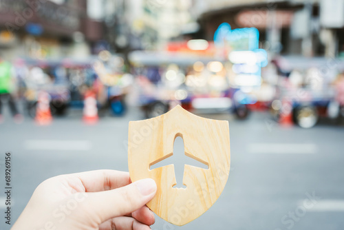 Shield protect icon with plane icon, blur TUK TUK in China town at Thailand. Security protection. The concept of travel insurance, covering medical expenses, emergency medical evacuation.