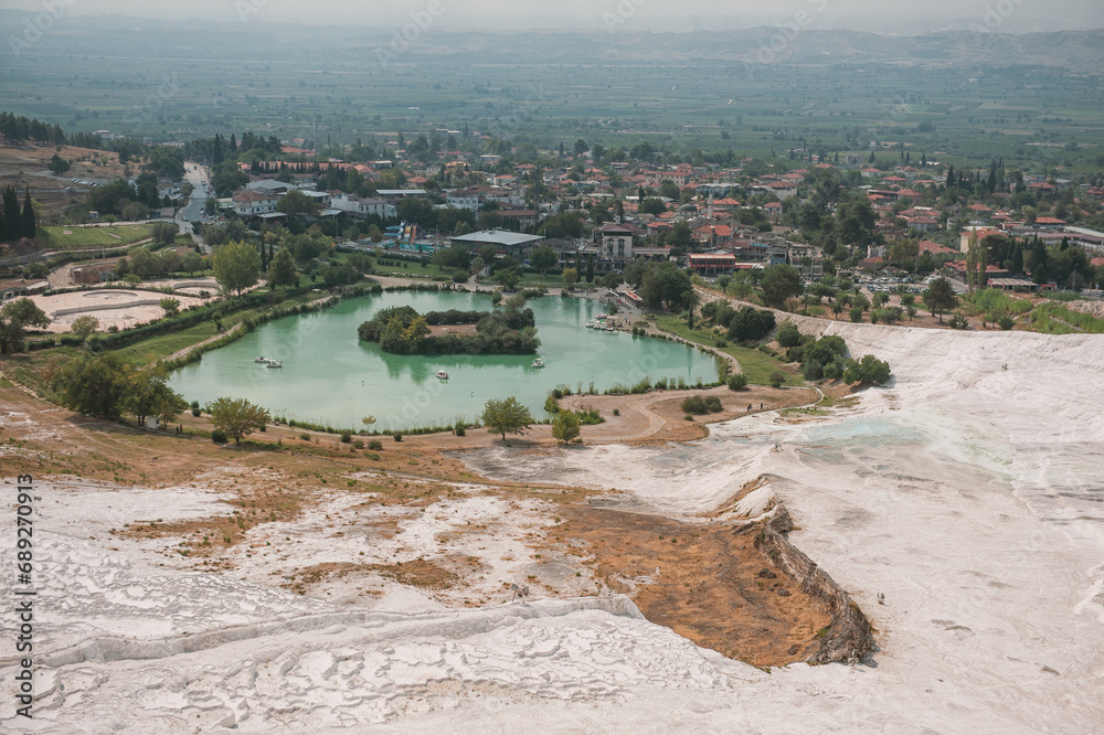 Beautiful landscape with calcium travertine terraces, blue pond and sky in Pamukkale, Turkey