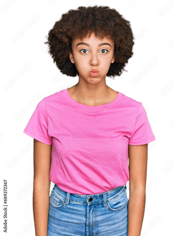 Young hispanic girl wearing casual clothes puffing cheeks with funny face. mouth inflated with air, crazy expression. Young hispanic girl wearing casual clothes puffing cheeks with funny face. mouth inflated with air, crazy expression.