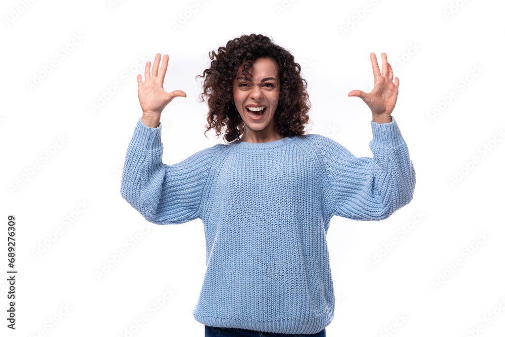 young confident lady with black curly hair dressed in a light blue sweater on a white background. people lifestyle concept young confident lady with black curly hair dressed in a light blue sweater on a white background. people lifestyle concept