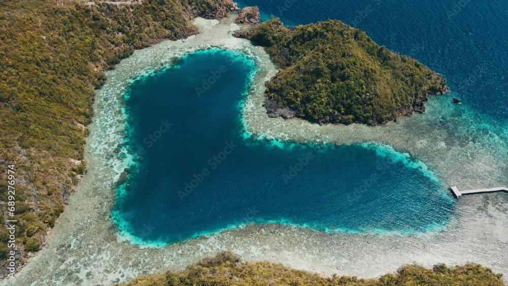 Love lake in Raja Ampat, Indonesia. Aerial view of the heart shaped lake with coral reefs in Misool region, West Papua
