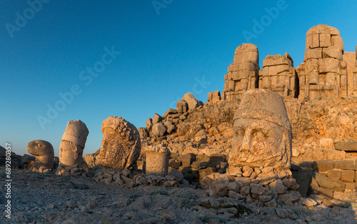 sunrise at the heads of ancient statues on East Terrace of Mount Nemrut, Turkey photo