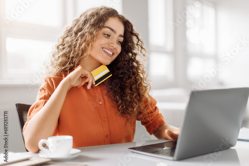 Happy shopper with credit card ready to buy online photo
