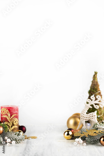 On a light background there is a small Christmas tree, a candle and New Year's decor. New Year background with space for writing text.