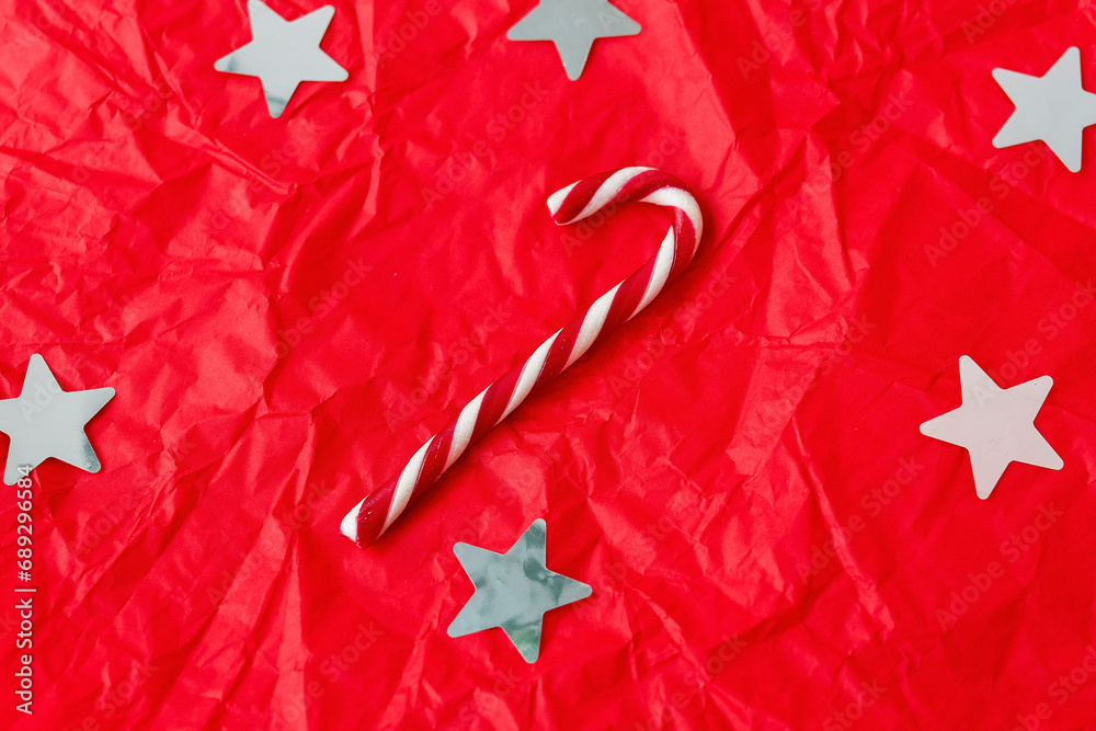 This is a bright and colorful Christmas background with white stars, a candy cane, and a crumpled texture.