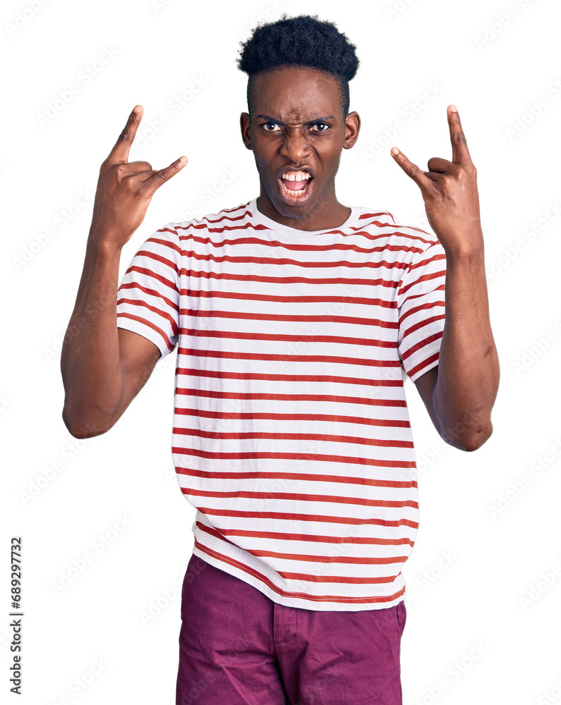 Young african american man wearing casual clothes shouting with crazy expression doing rock symbol with hands up. music star. heavy concept. Young african american man wearing casual clothes shouting with crazy expression doing rock symbol with hands up. music star. heavy concept.