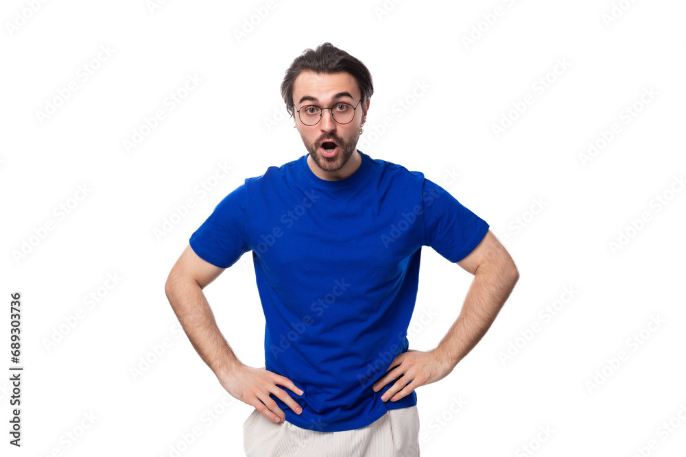 young suspicious brunette european man with a well-groomed beard in a blue t-shirt on a white background with copy space young suspicious brunette european man with a well-groomed beard in a blue t-shirt on a white background with copy space