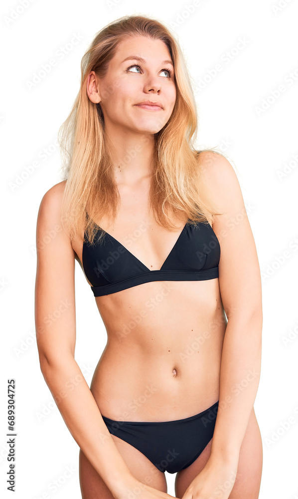 Young beautiful blonde woman wearing bikini smiling looking to the side and staring away thinking. Young beautiful blonde woman wearing bikini smiling looking to the side and staring away thinking.