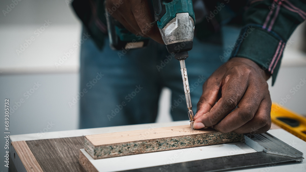 Carpenter making woodworks handcrafted furniture in wood workshop. Furniture Designer working on woodworking machines in furniture factory.