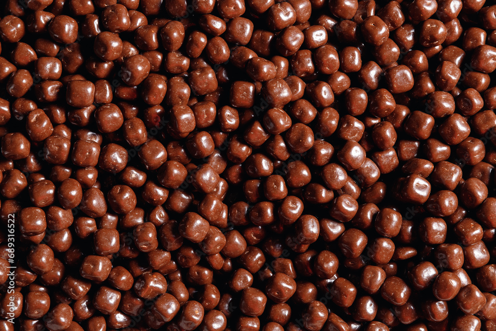 Closeup brown dragee, chocolate covered nuts, sweet candy background Closeup brown dragee, chocolate covered nuts, sweet candy background