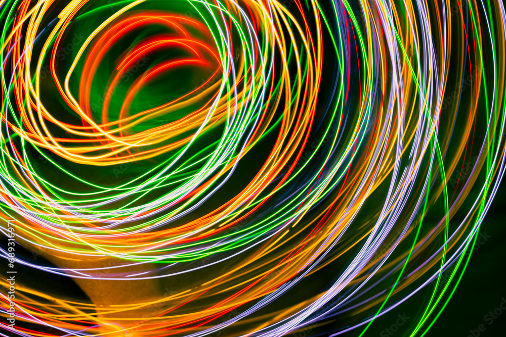Abstract multi-colored light , swirl and curve of blue, green and red bright light tracks against a black background