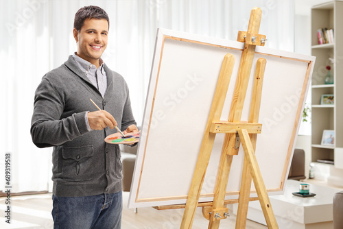 Young man painting on a canvas at home