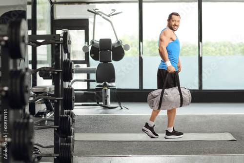 Man with a sports bag walking in a gym