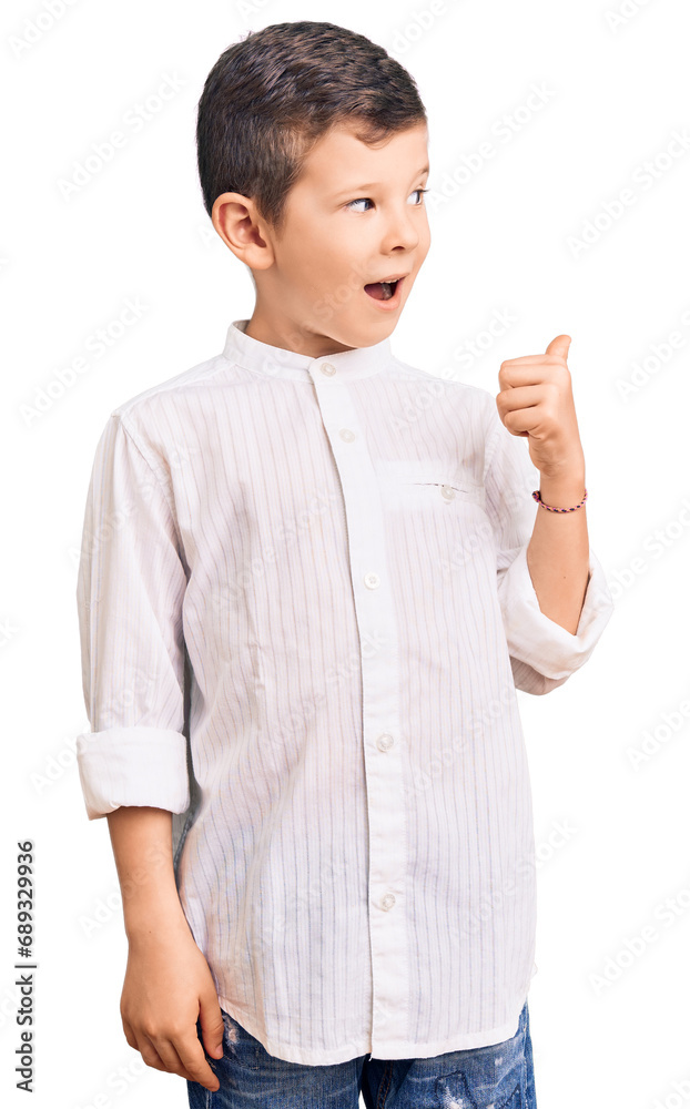 Cute blond kid wearing elegant shirt smiling with happy face looking and pointing to the side with thumb up. Cute blond kid wearing elegant shirt smiling with happy face looking and pointing to the side with thumb up.