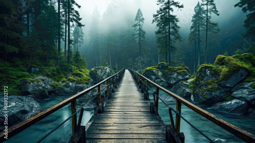 Wooden bridge on a mountain river in the misty morning. photo