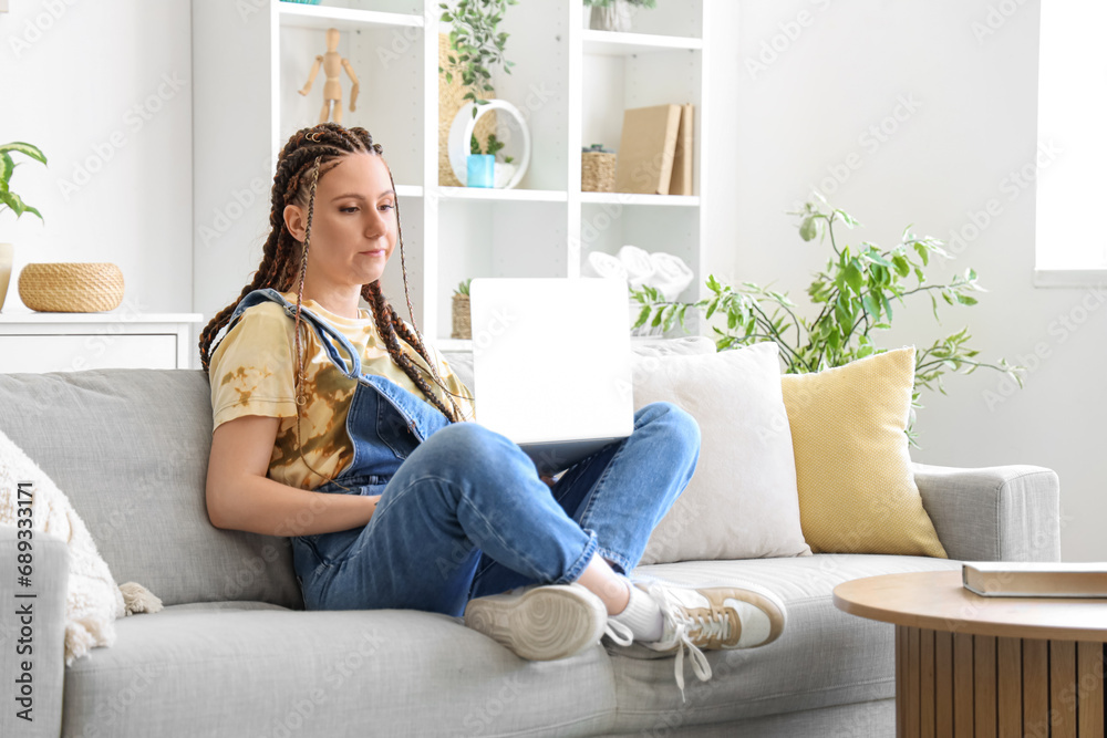 Young woman with dreadlocks using laptop at home Young woman with dreadlocks using laptop at home