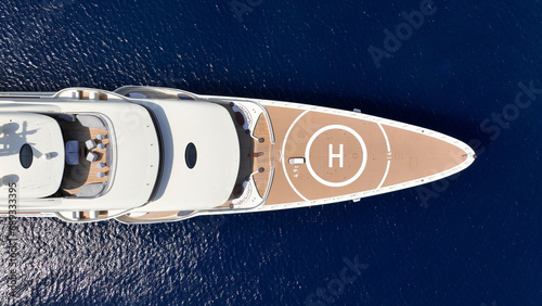 Aerial drone ultra wide top down panoramic photo with copy space of luxury yacht with wooden deck anchored in deep blue island bay with crystal clear sea © aerial-drone