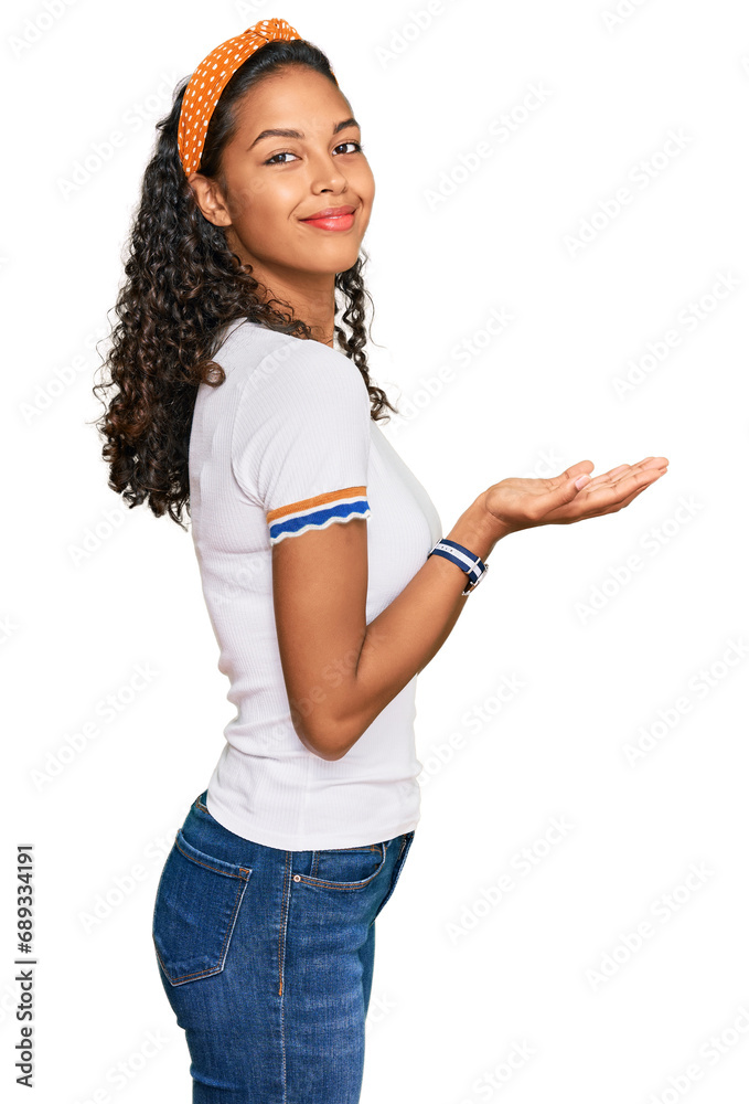 Young african american girl wearing casual clothes pointing aside with hands open palms showing copy space, presenting advertisement smiling excited happy Young african american girl wearing casual clothes pointing aside with hands open palms showing copy space, presenting advertisement smiling excited happy