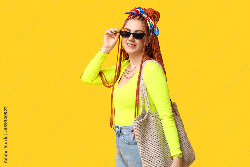 Portrait of fashionable young woman with dreadlocks on yellow background Portrait of fashionable young woman with dreadlocks on yellow background