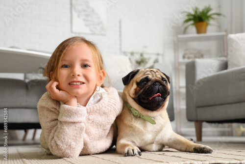 Little girl with cute pug d...