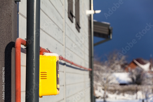 Gas meter on the facade of a house against the background of a chimney in the wall