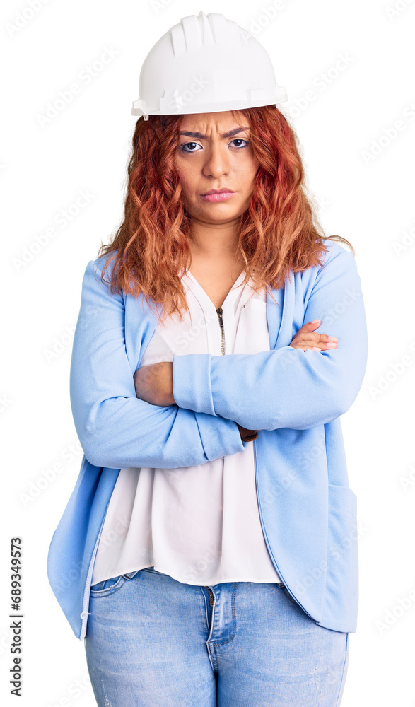Young latin woman wearing architect hardhat skeptic and nervous, disapproving expression on face with crossed arms. negative person. Young latin woman wearing architect hardhat skeptic and nervous, disapproving expression on face with crossed arms. negative person.