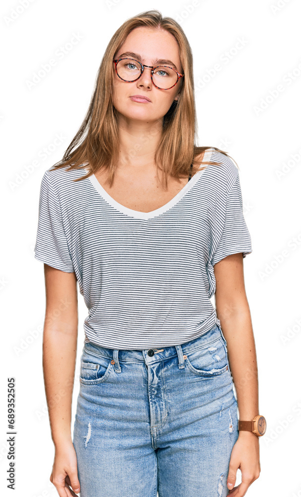 Beautiful young blonde woman wearing casual clothes and glasses relaxed with serious expression on face. simple and natural looking at the camera. Beautiful young blonde woman wearing casual clothes and glasses relaxed with serious expression on face. simple and natural looking at the camera.